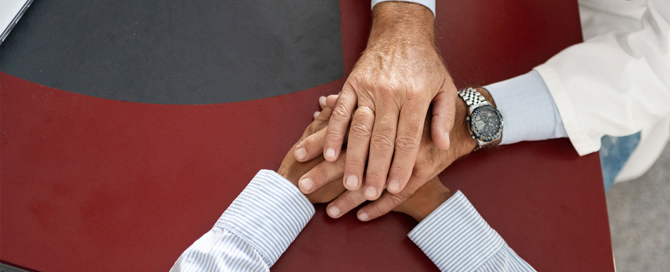 Arzt hält die Hände seines Patienten